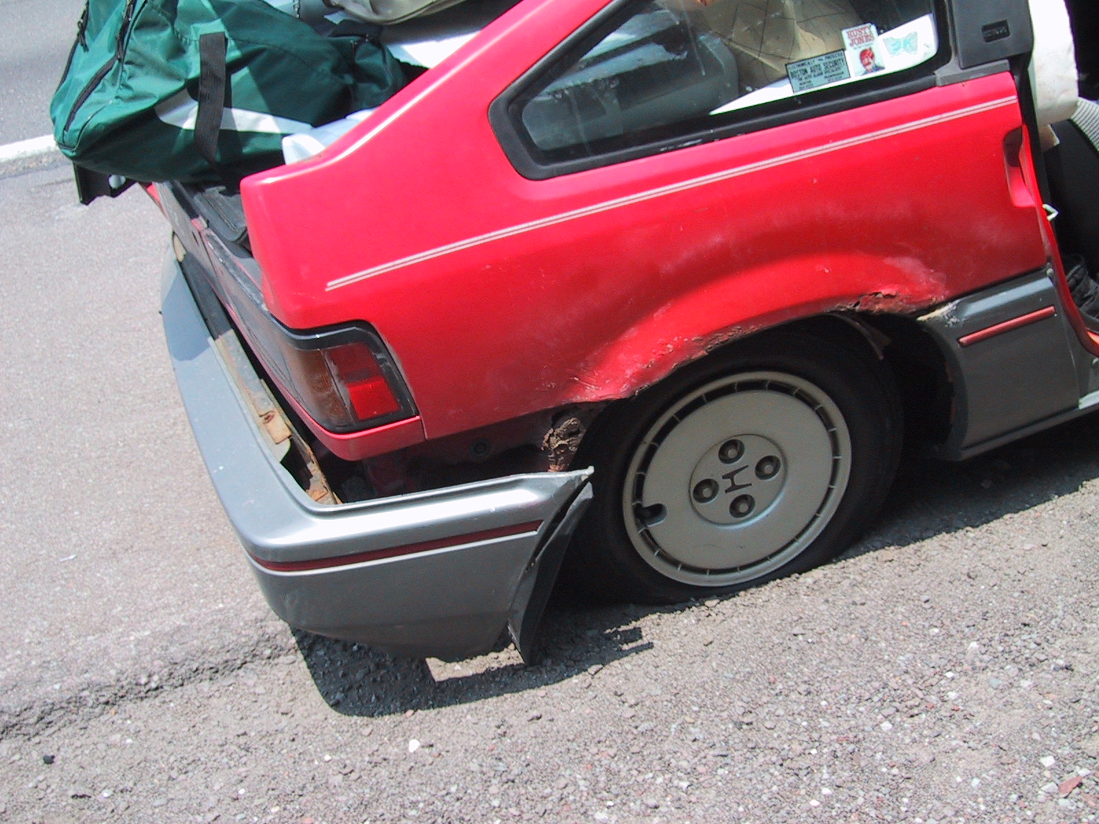 there is a broken red car parked outside