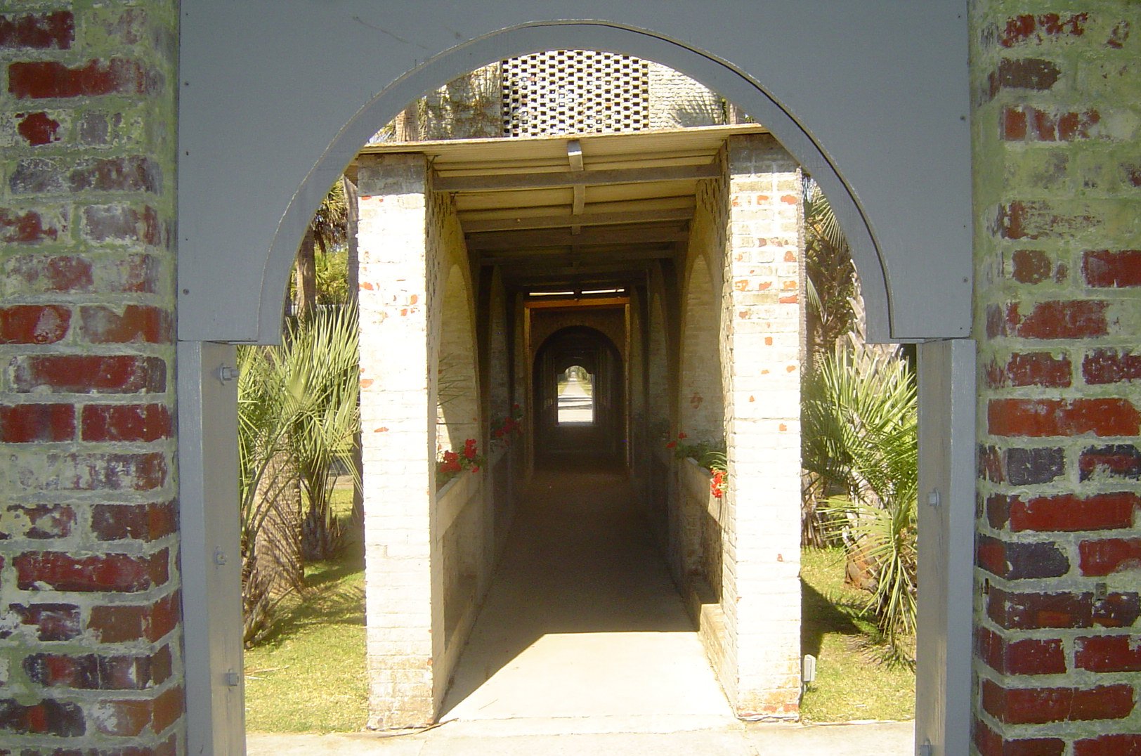 an archway leads to a house in a garden