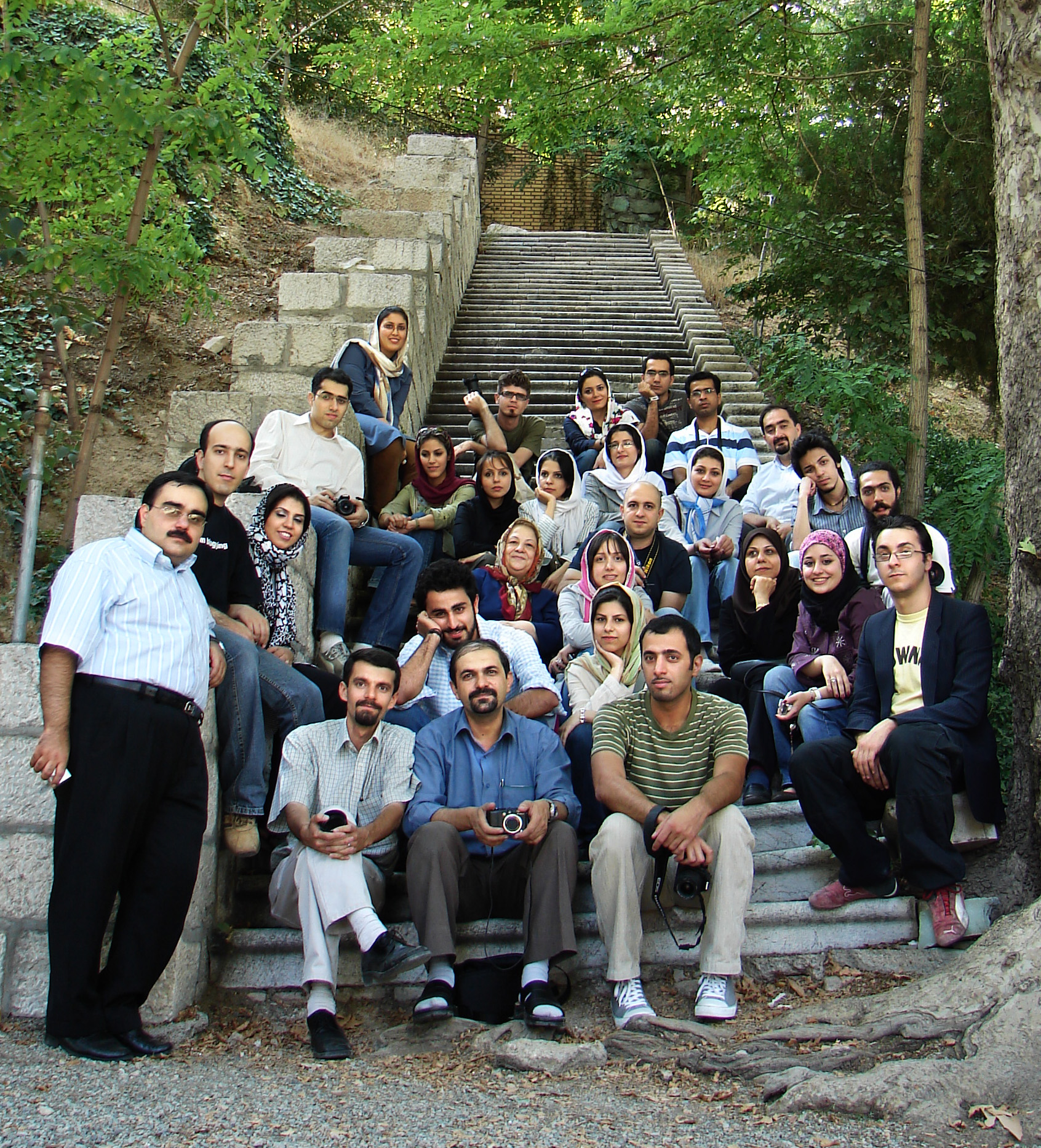 a group of people pose for a po on steps in the forest