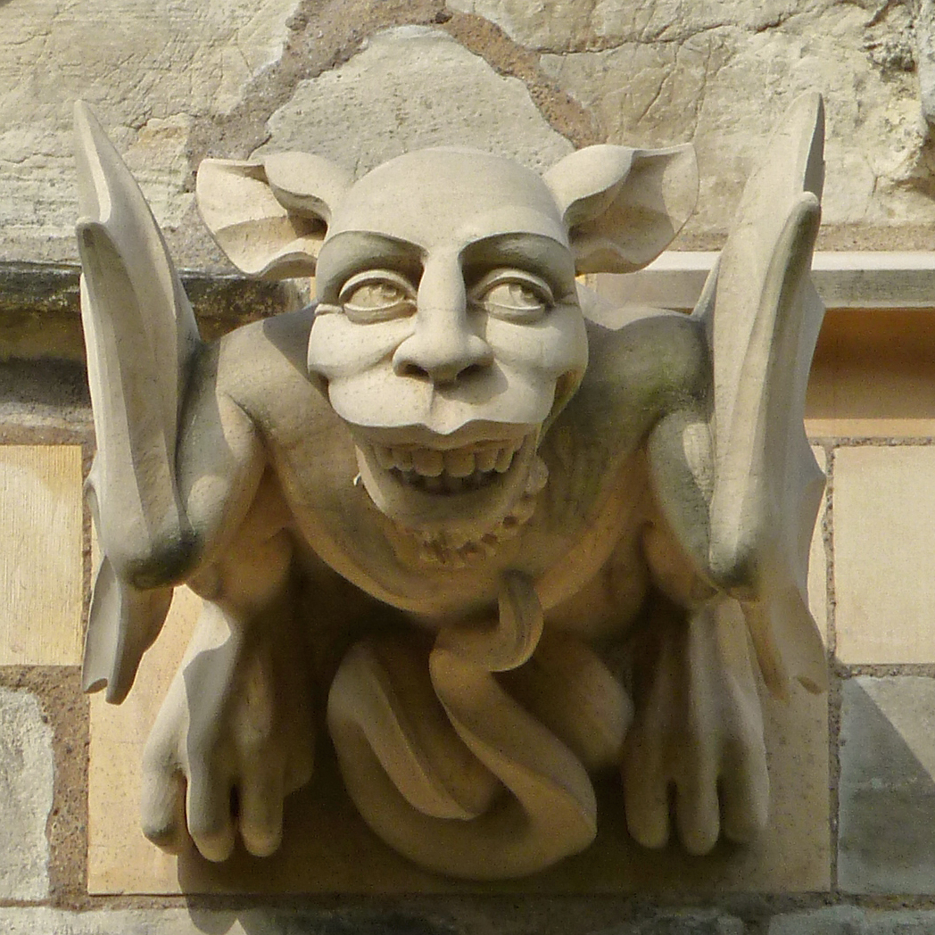 gargoyle sculpture on side of stone building with horns