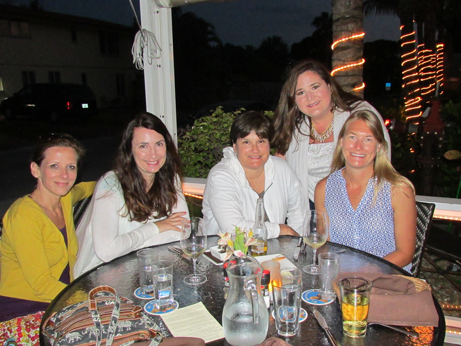 a group of women standing around a table