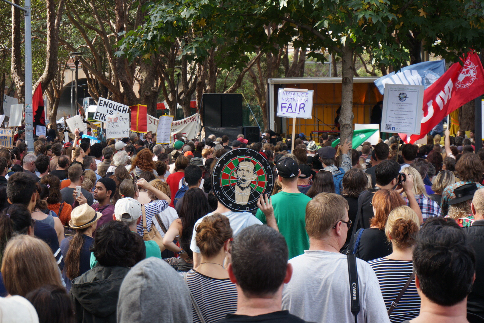 a group of people holding up flags and a sign