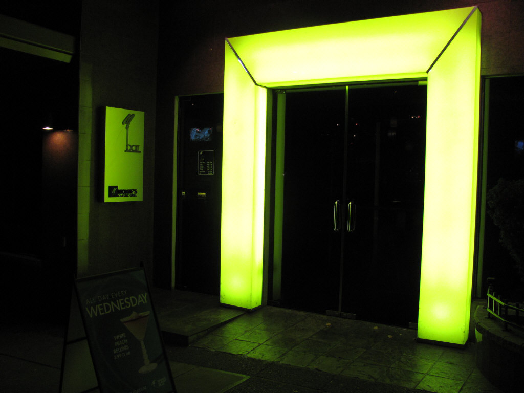 a green door with black doors and an advertit sign