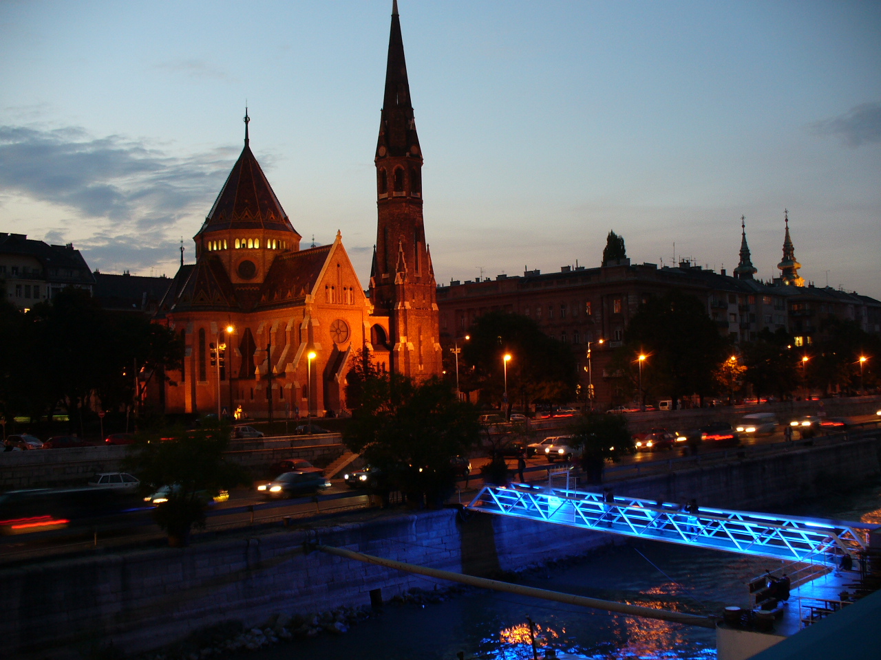 a bridge is lit up near some buildings