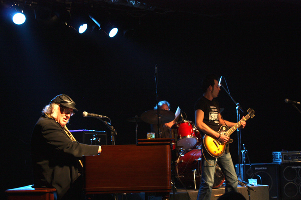 man playing guitar with a keyboard on stage