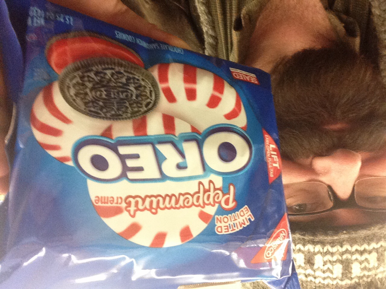 a man holding a bag of oreo cookies in front of his face