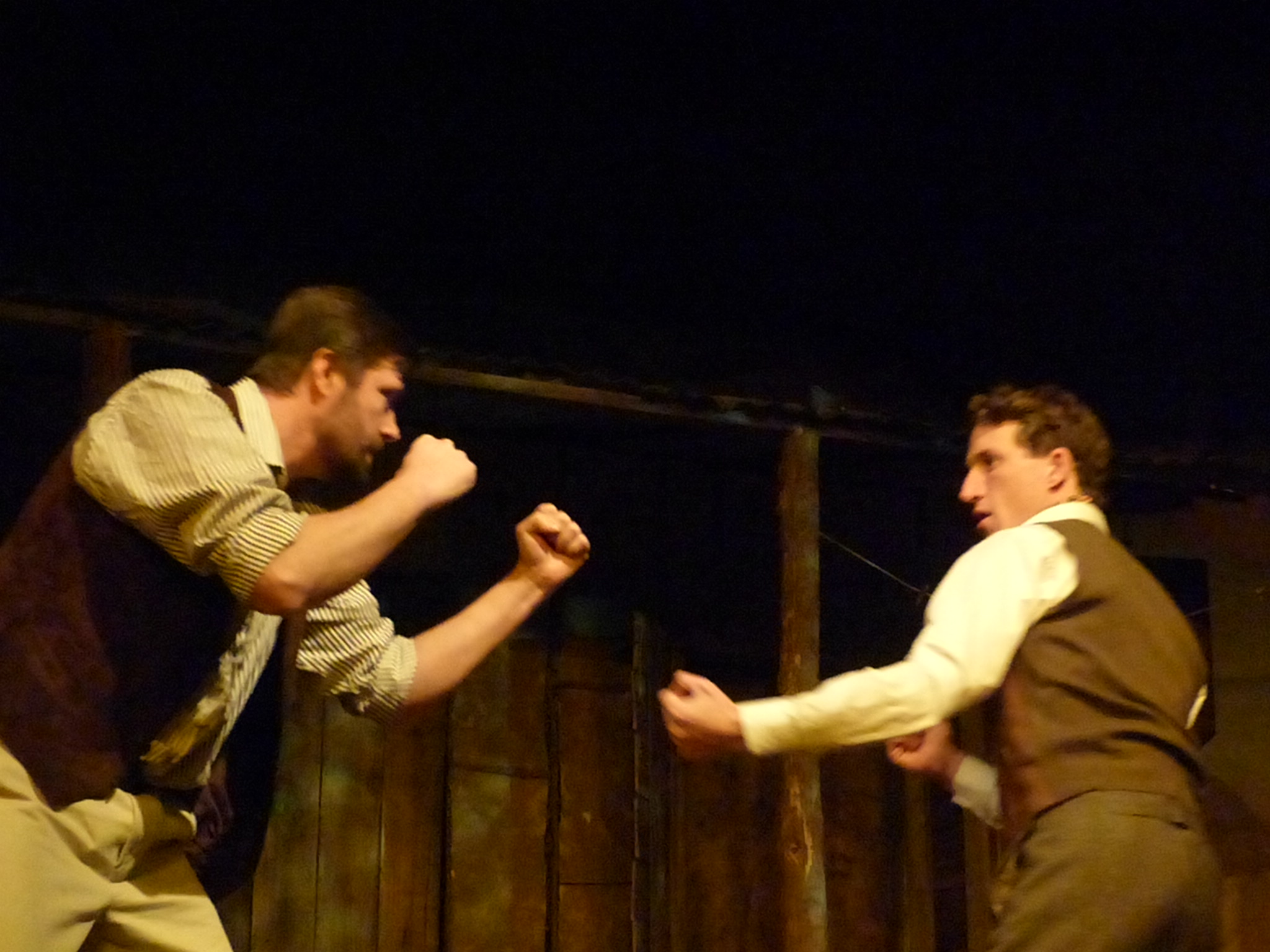 two men fighting over soing on a stage