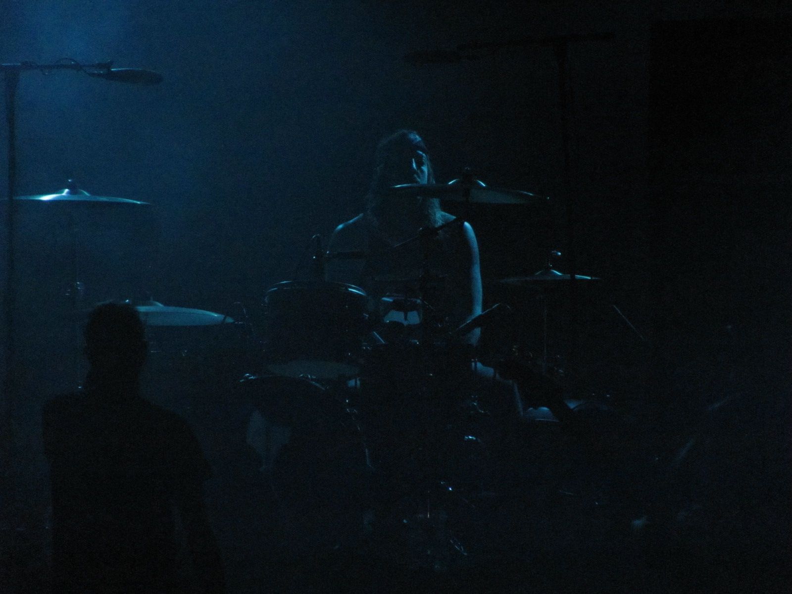 two men on stage in the dark playing instruments