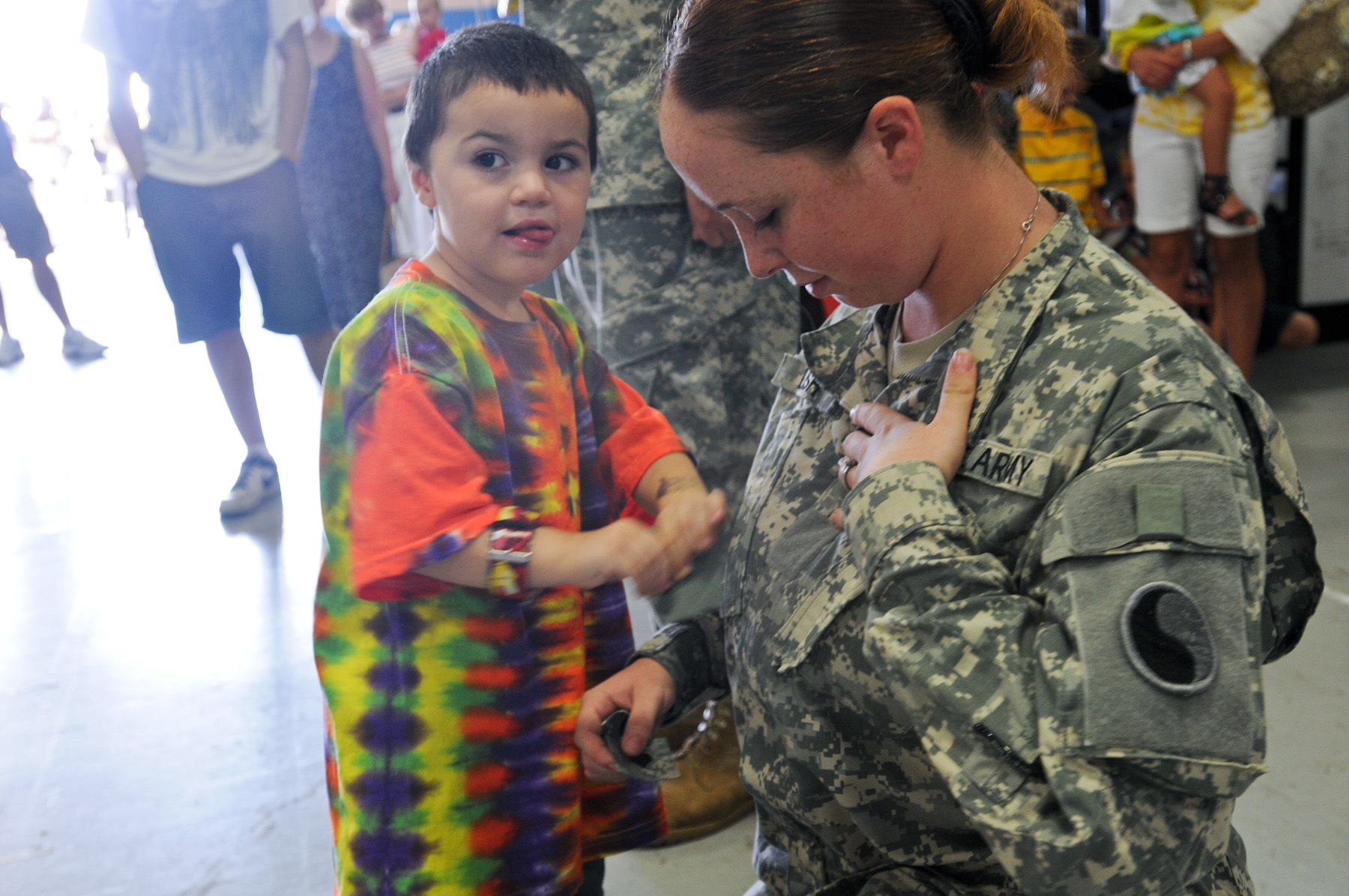 a woman holding the hand of a small child dressed in colorful clothes