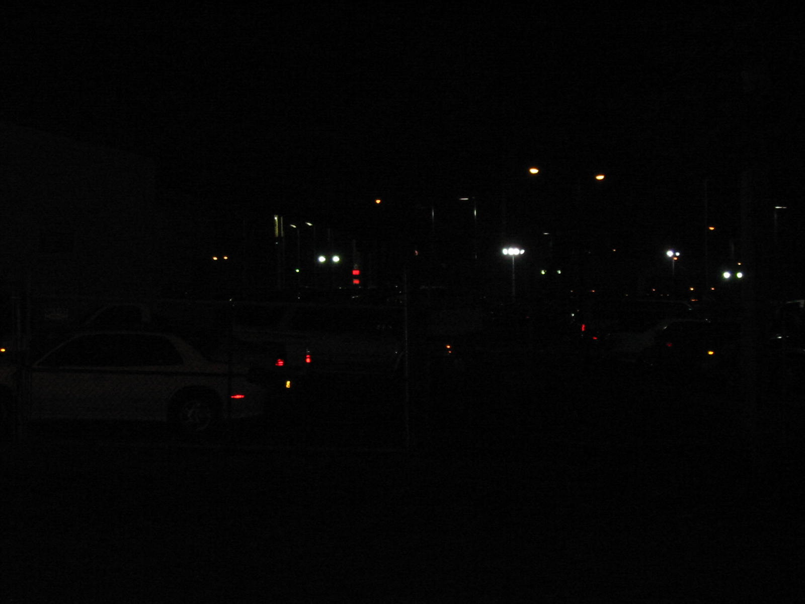 a nighttime scene with a street light and cars