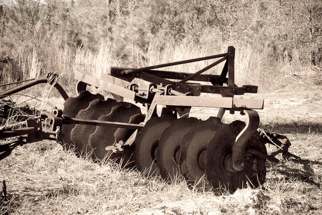 a large tractor with a metal raked top on grass