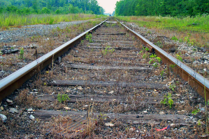a railroad track sitting in the middle of a field