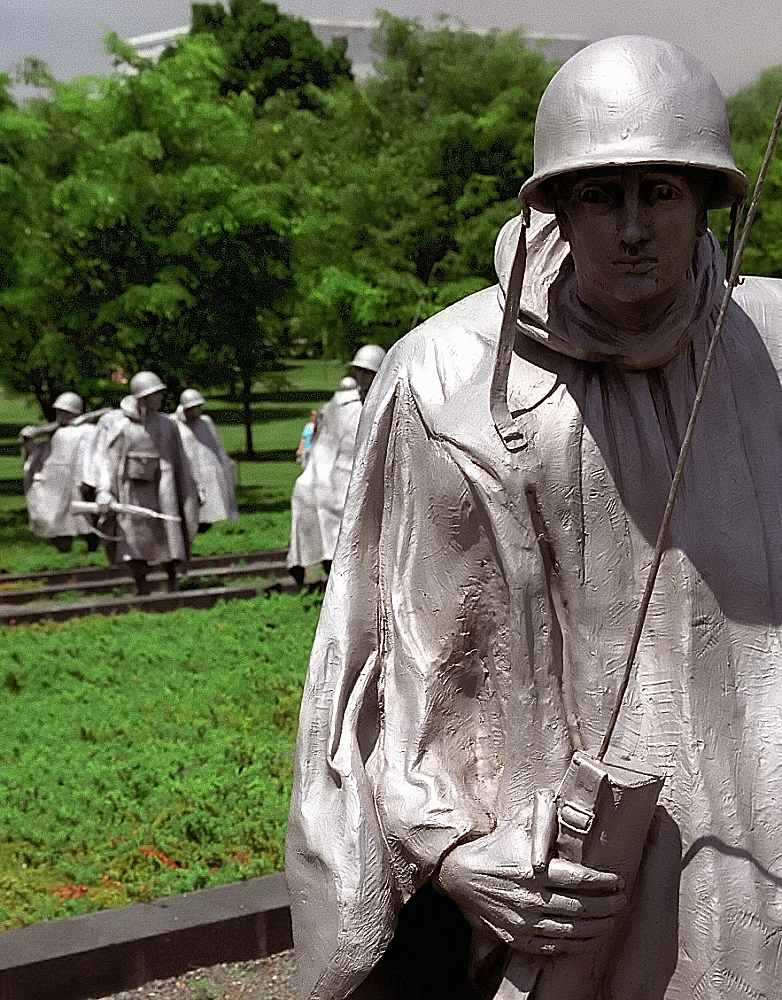 a statue of a soldier with other soldiers in a field