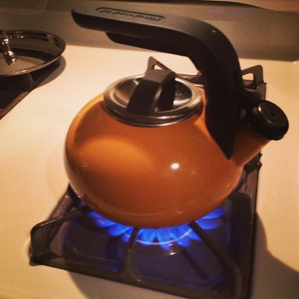 the tea kettle has a burner on the side of it