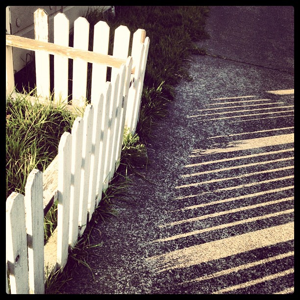 a white fence on the side of a road