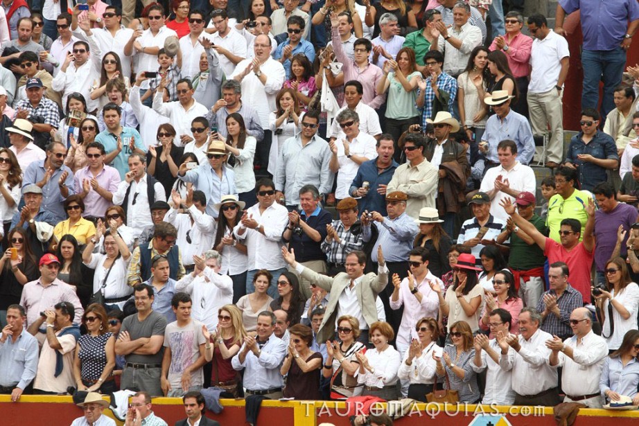 a large crowd of people waving in front of a tennis court