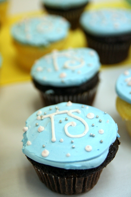 cupcakes with blue icing and white frosting have stars around them