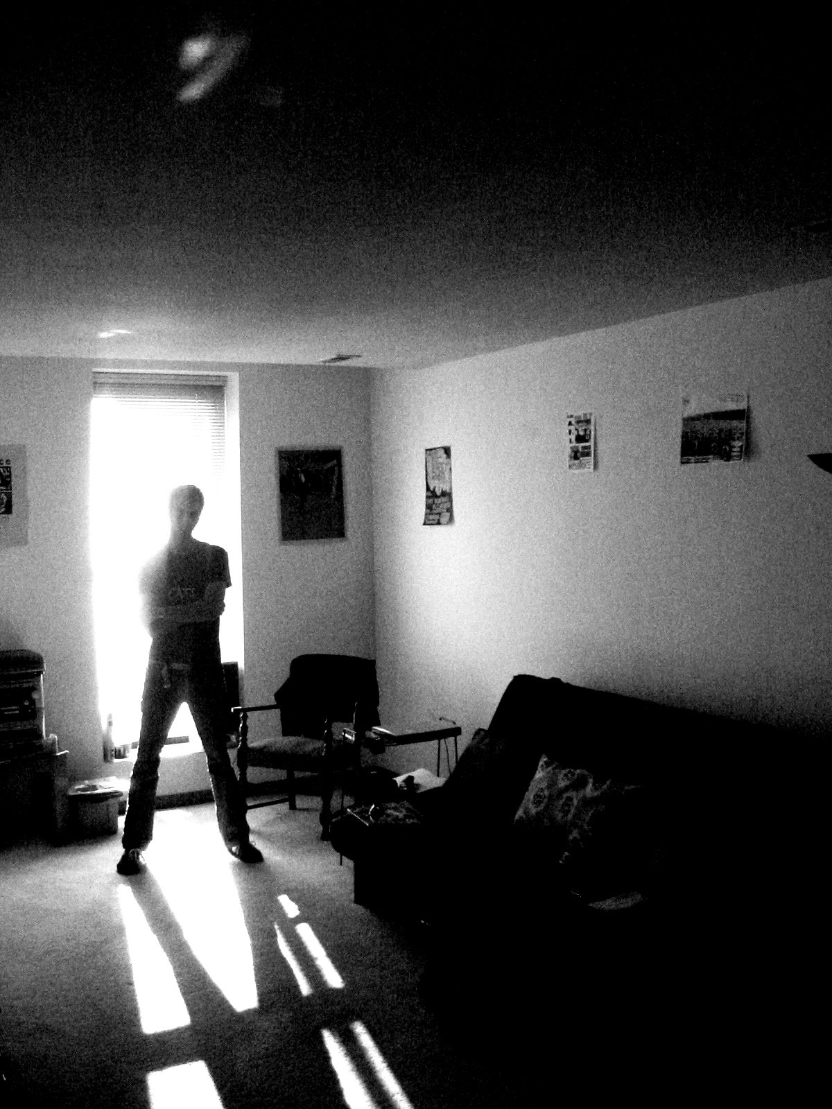 a man standing in front of a door next to a living room filled with furniture
