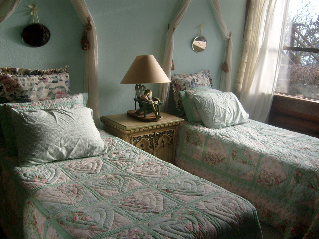 two beds side by side in a bedroom with two lamps