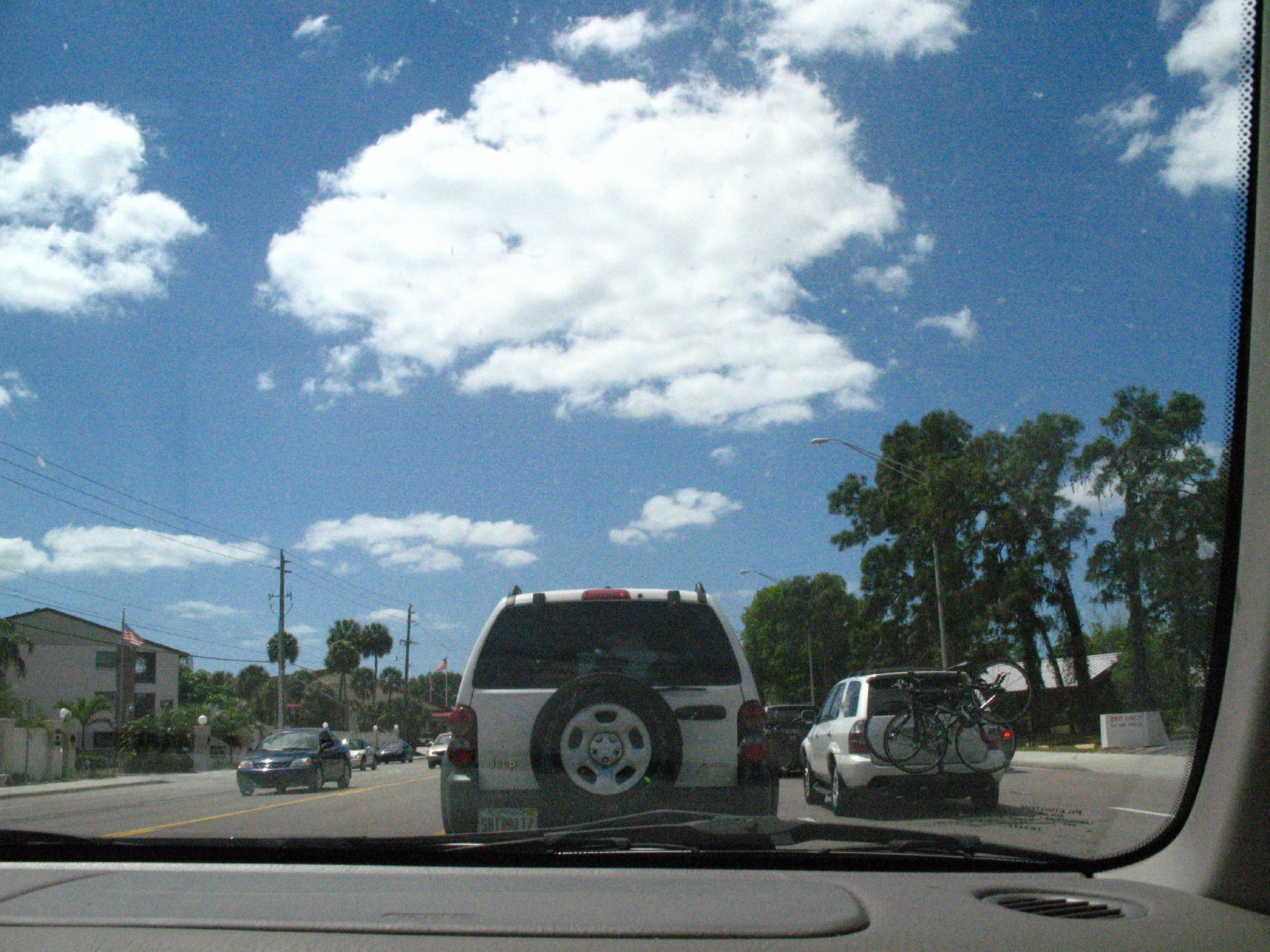 view from the backseat of a moving vehicle, driving through an intersection