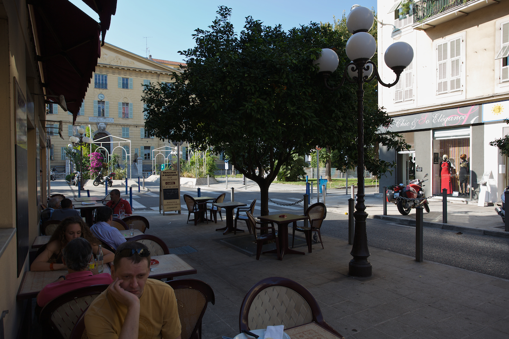 several people are sitting at tables and some trees