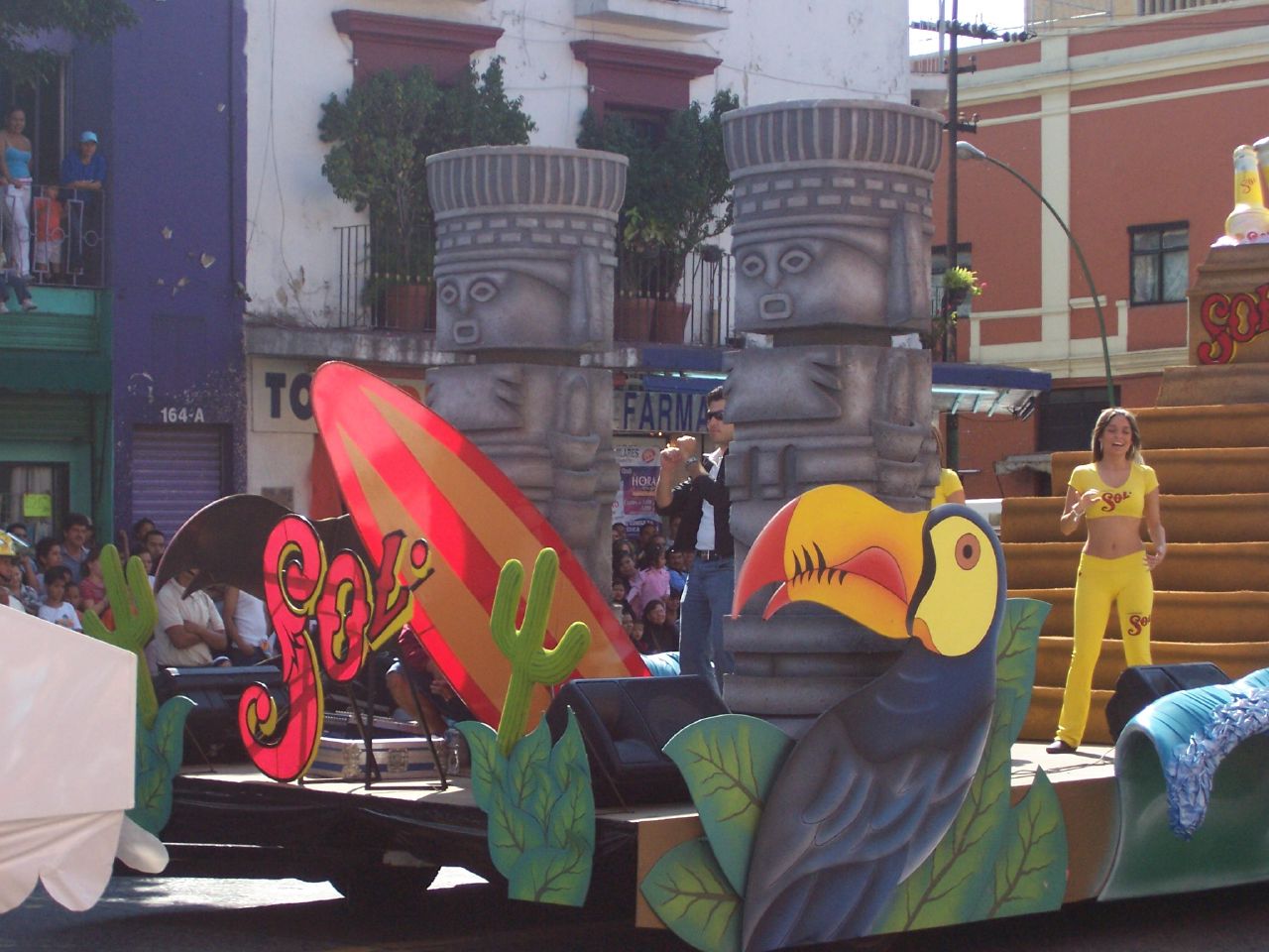 a parade float with a bird, bird, and tropical scene