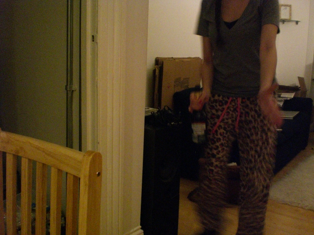 a woman in leopard print pants and sneakers standing next to a room