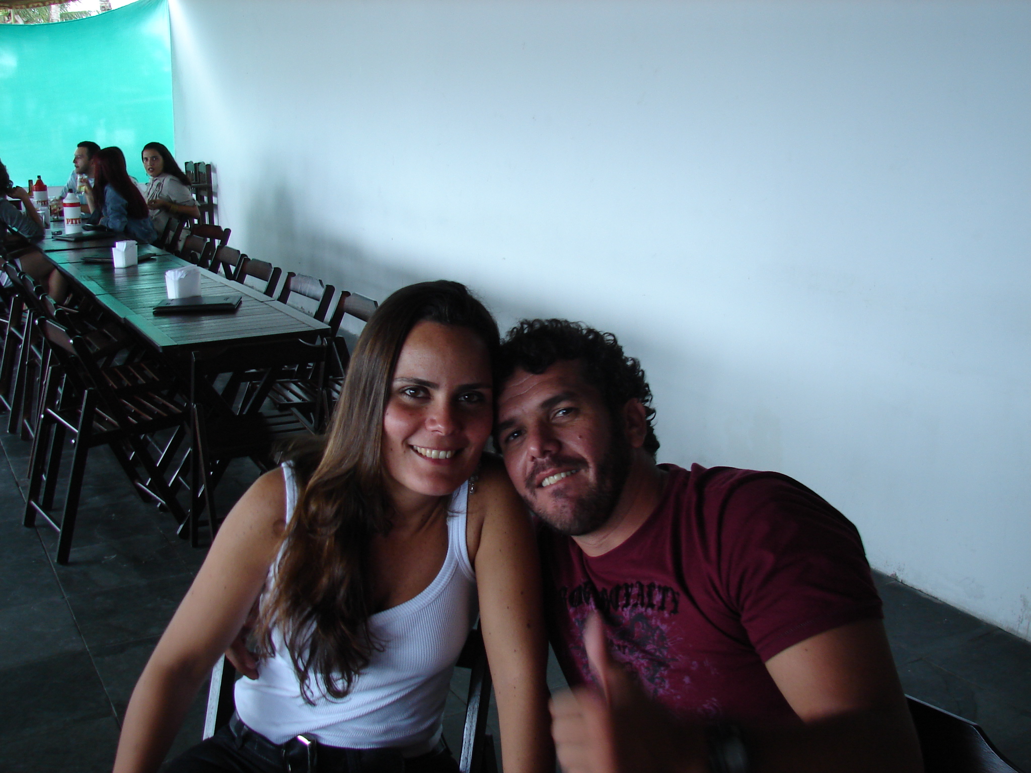 a couple posing together with a restaurant in the background