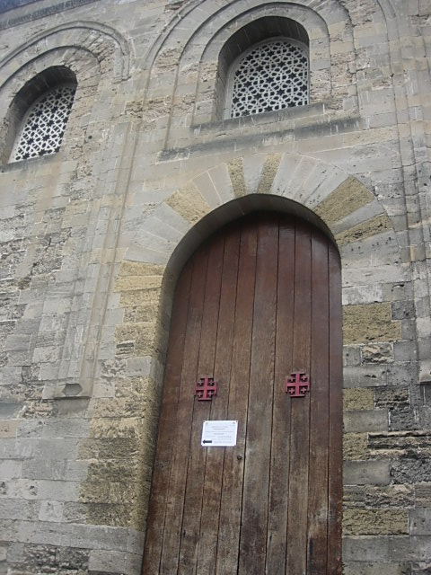 a stone church with two large wooden doors