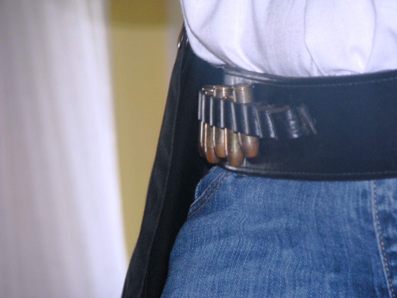 a woman is wearing a belt and denim jeans