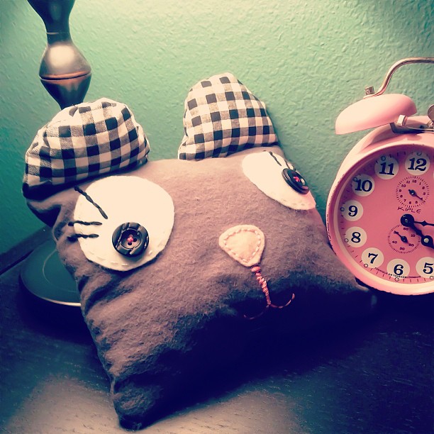 an alarm clock with a kitty pillow