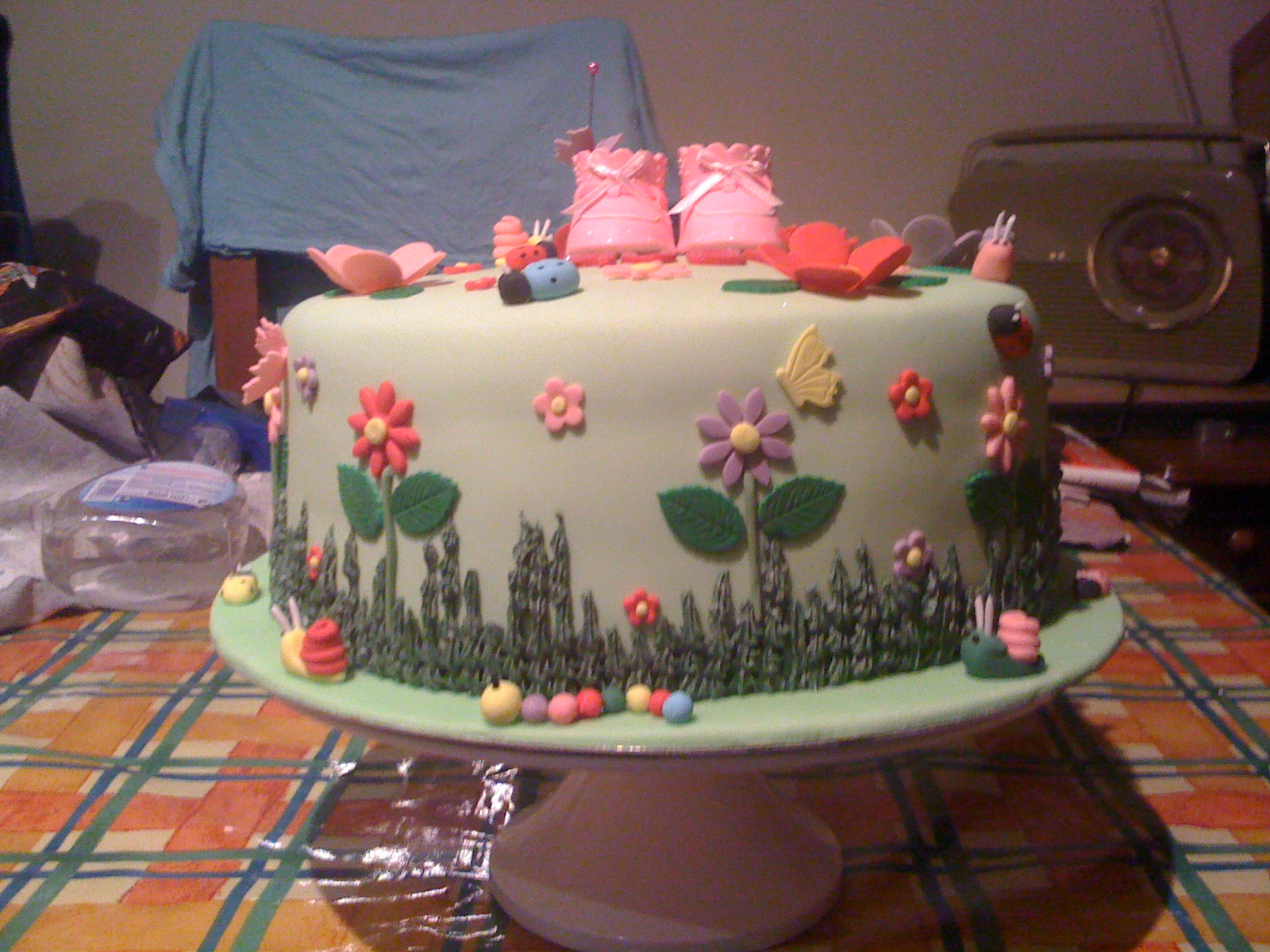 a cake is decorated with little pigs sitting on flowers