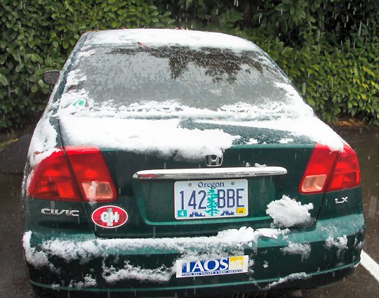 a green car with snow all over it