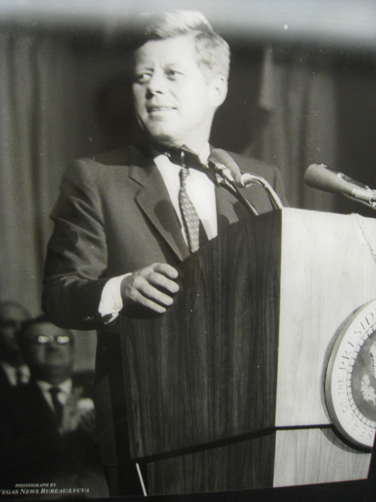 a man in a suit standing at a podium