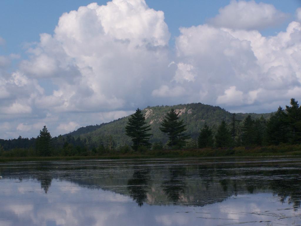 the large lake is full of water as clouds loom above it