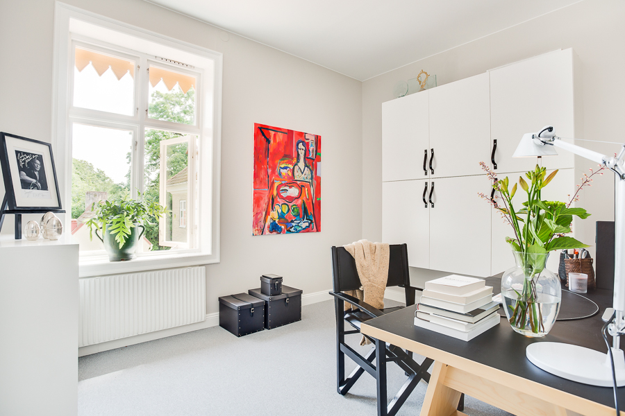 a room with a table, chairs, windows and pictures on the wall