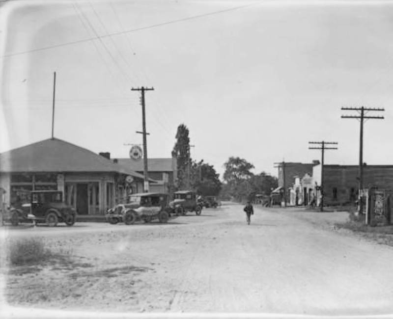 an old picture of people walking down a street