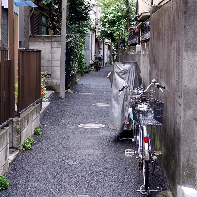 an empty alley with a bicycle and a covered cover