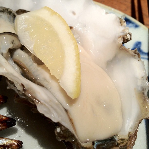 an oyster with a slice of lemon on it on a plate