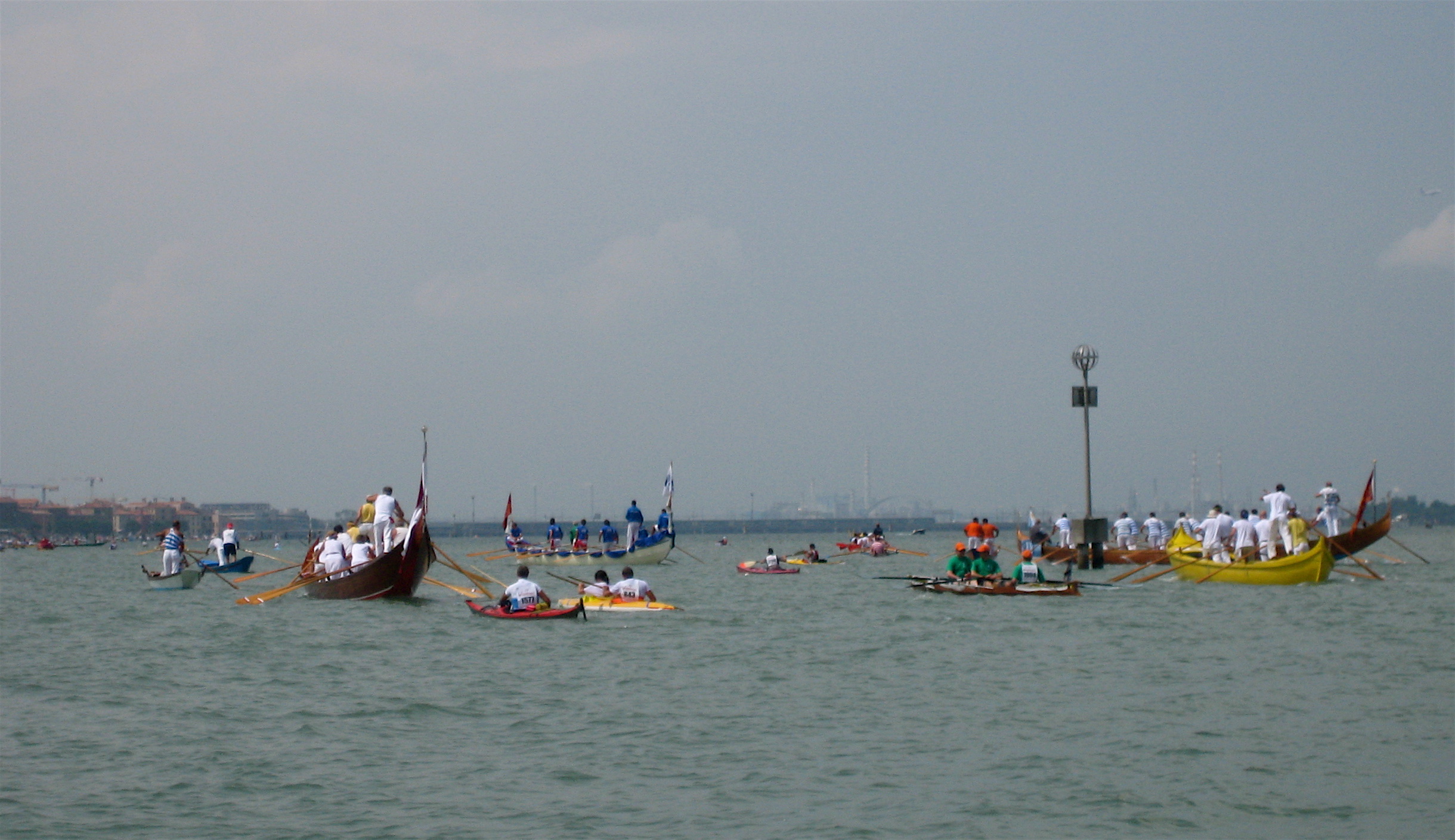 many canoes are in the water on a cloudy day