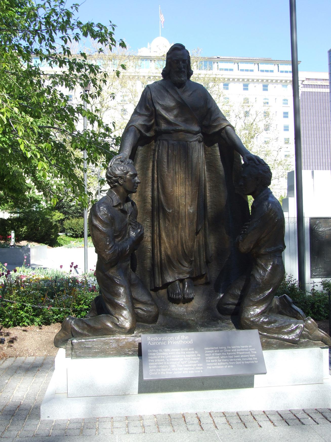 a large bronze statue of a man holding hands with two s