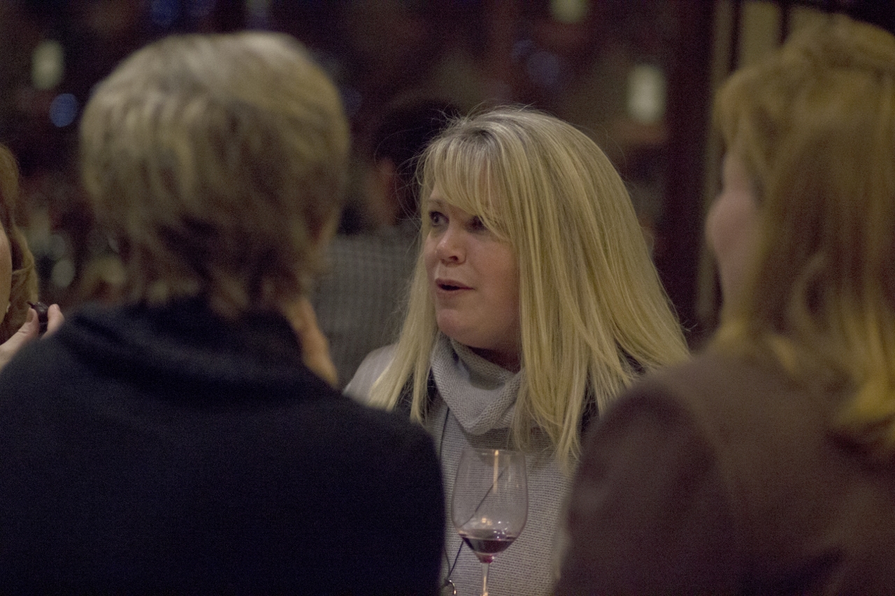 some women sitting and talking at a wine tasting event