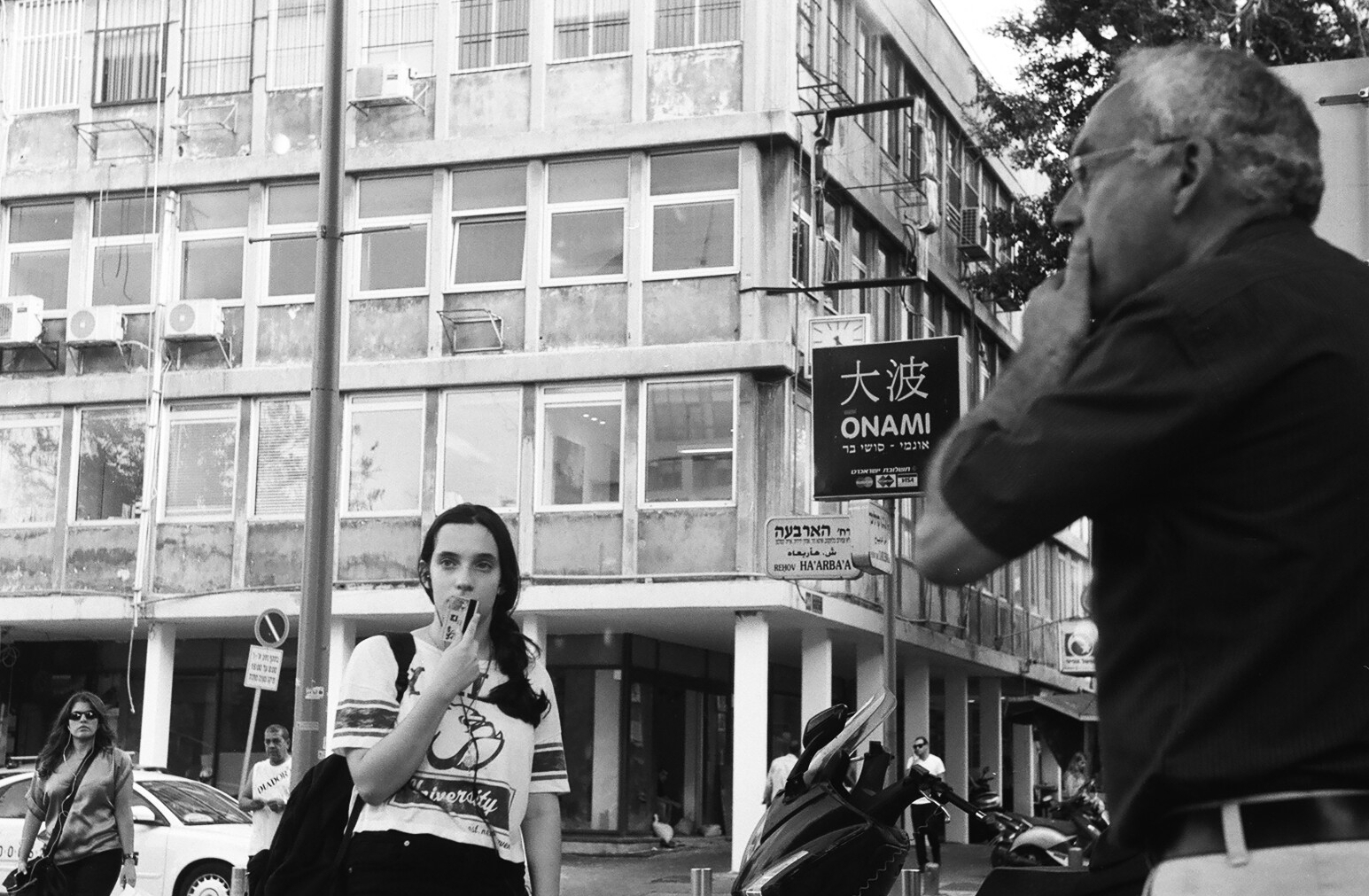 a woman walking on the side of the road while talking on her cell phone