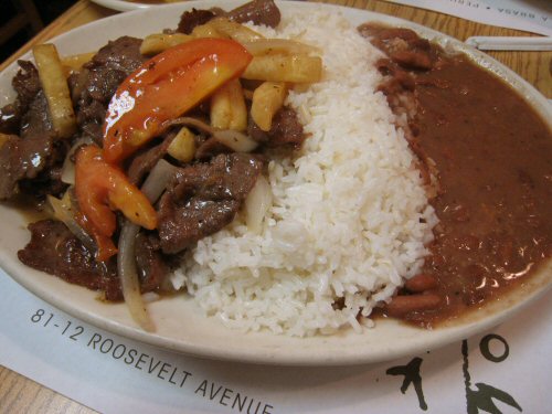 a white plate filled with rice and veggies and meat
