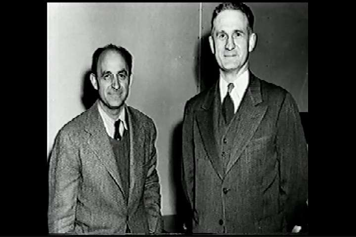 two men are dressed formally in suits and ties