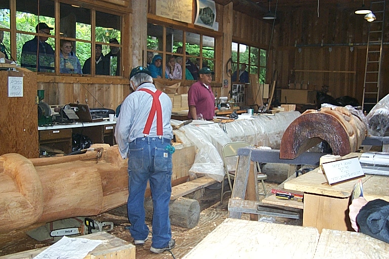 several people in wooden shop with lots of lumber