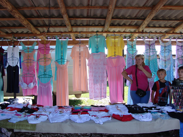 a woman standing next to s with laundry on tables