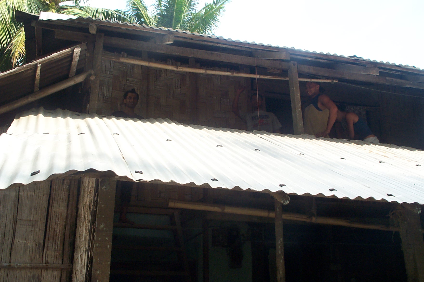 a man and a woman sit in an open window of a wooden house