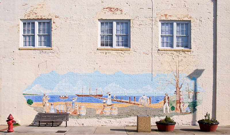 the mural depicts a city scene on a large brick building