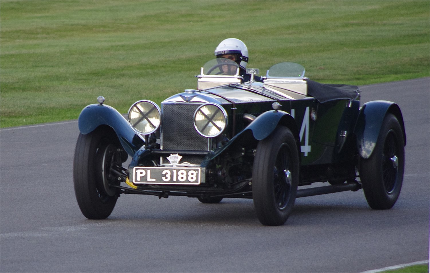 an old vintage car is driving on the track